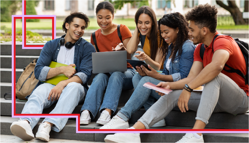 Five young adults sit on outdoor steps, smiling and interacting while looking at a laptop and tablet. They appear to be studying or collaborating in a casual, friendly setting.