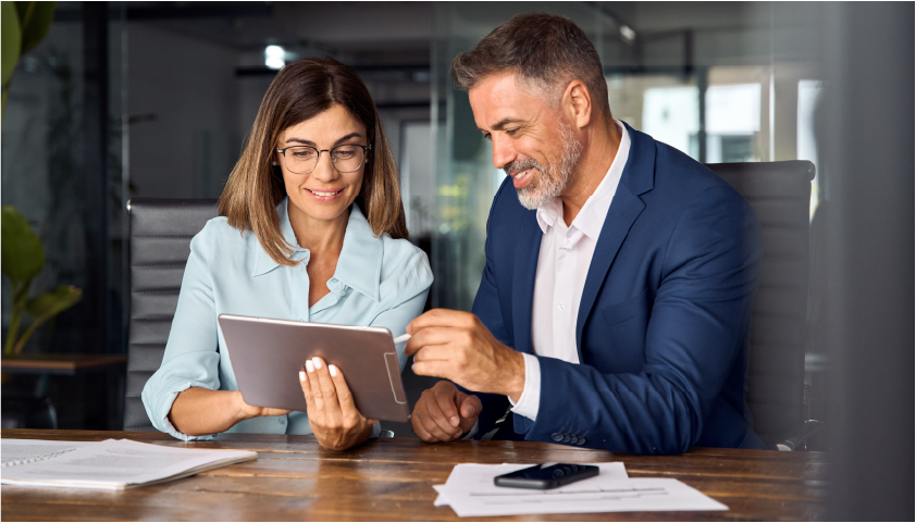 A man and a woman looking at a tablet discussing a project.