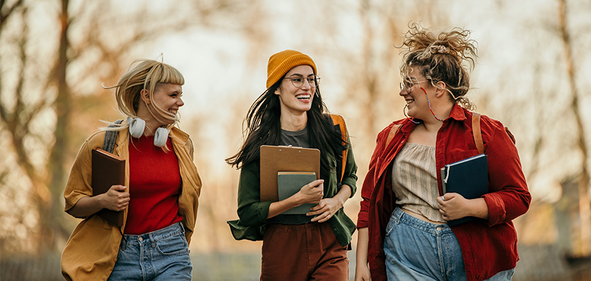 3 female students walking laughing together